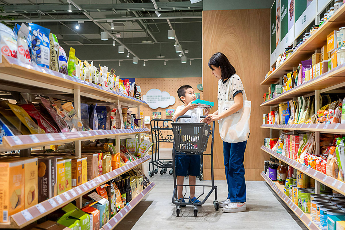 一位家長與孩子在里仁門市查看商品