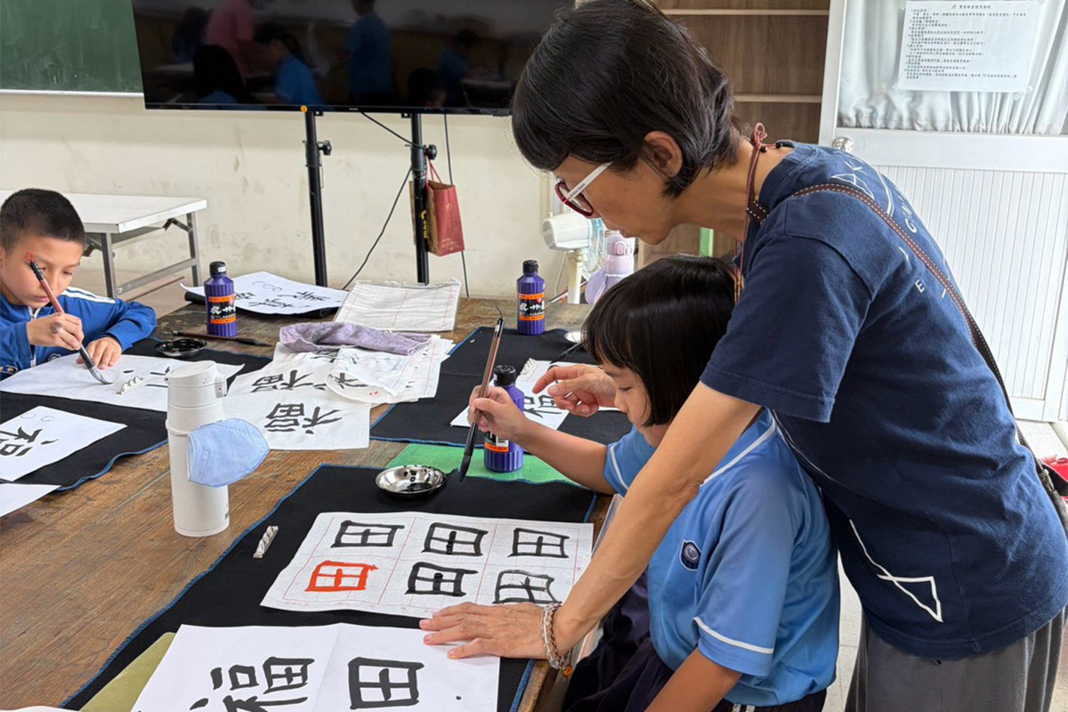 老師教導學生練習書法