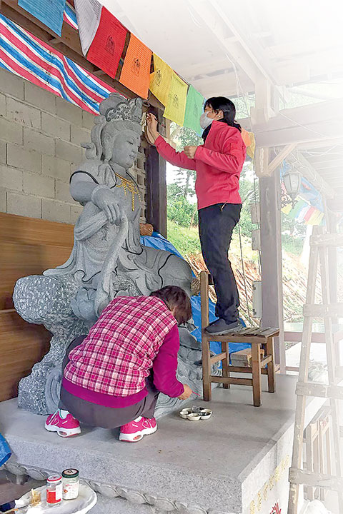 鳳山寺大殿後的平臺，正彩繪聖像的李依霖 (站立者)。